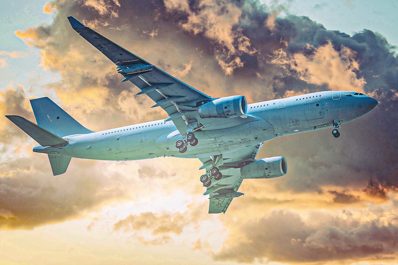 Gray twin-engine Airbus aircraft descending with landing gear extended.