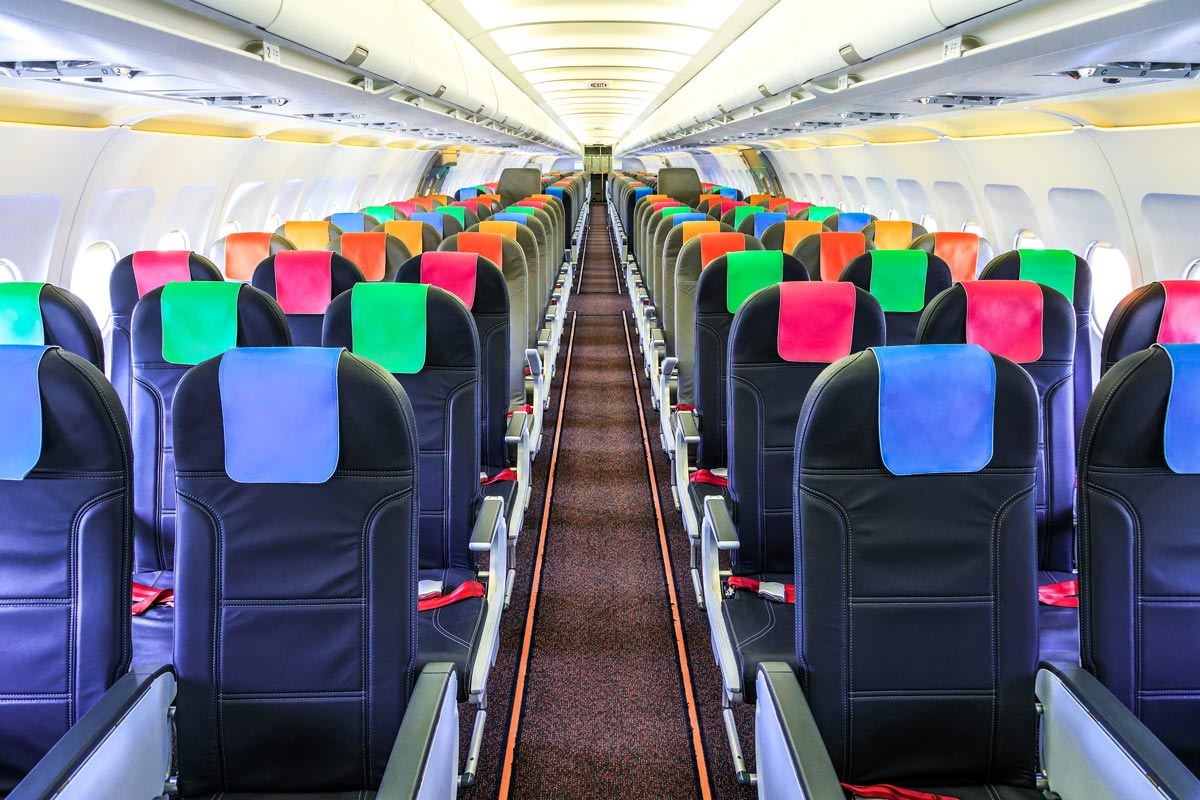 Passenger cabin with black seats and colorful headrest covers.