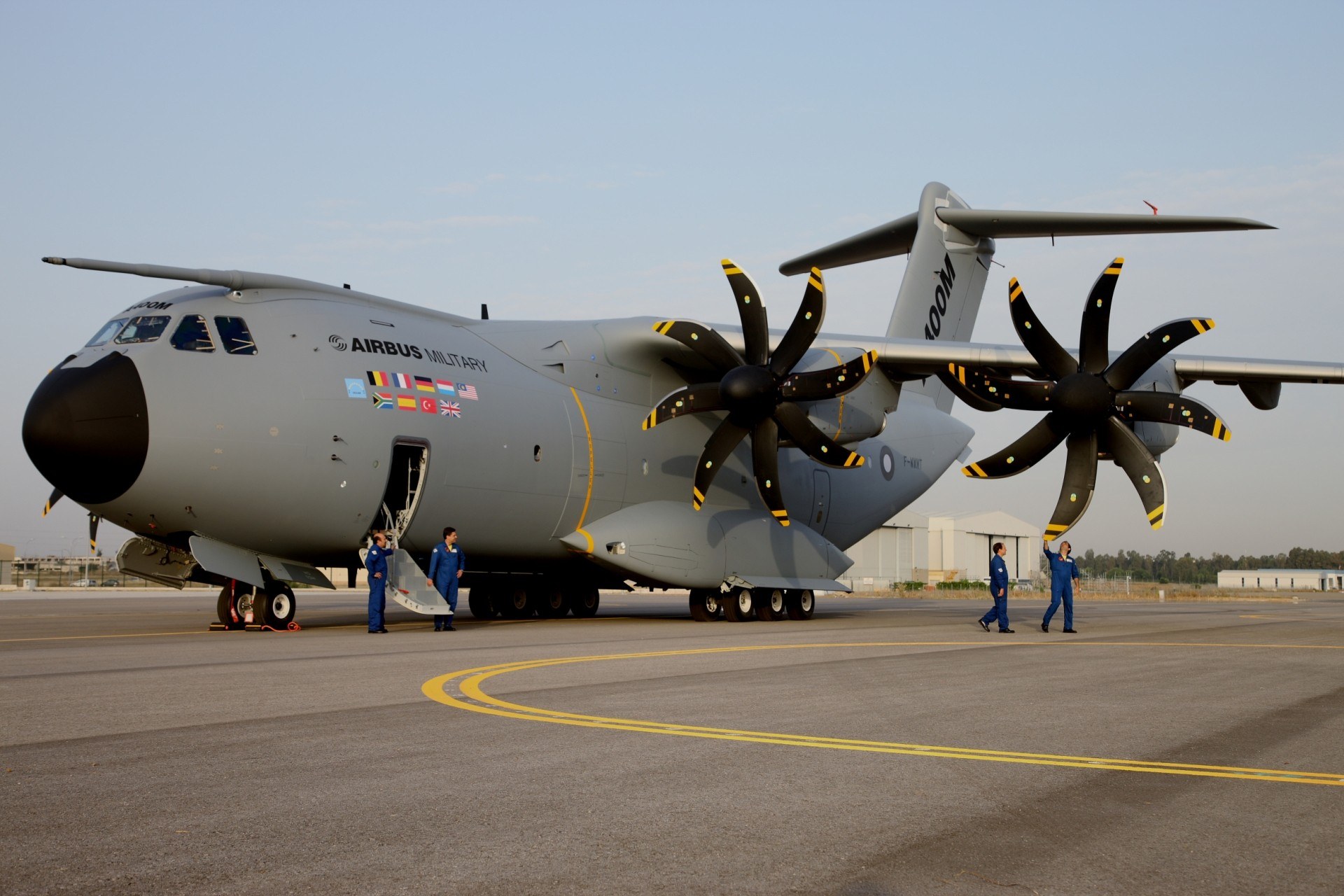 Gray Airbus Military A400M Atlas parked on a ramp with crew nearby.