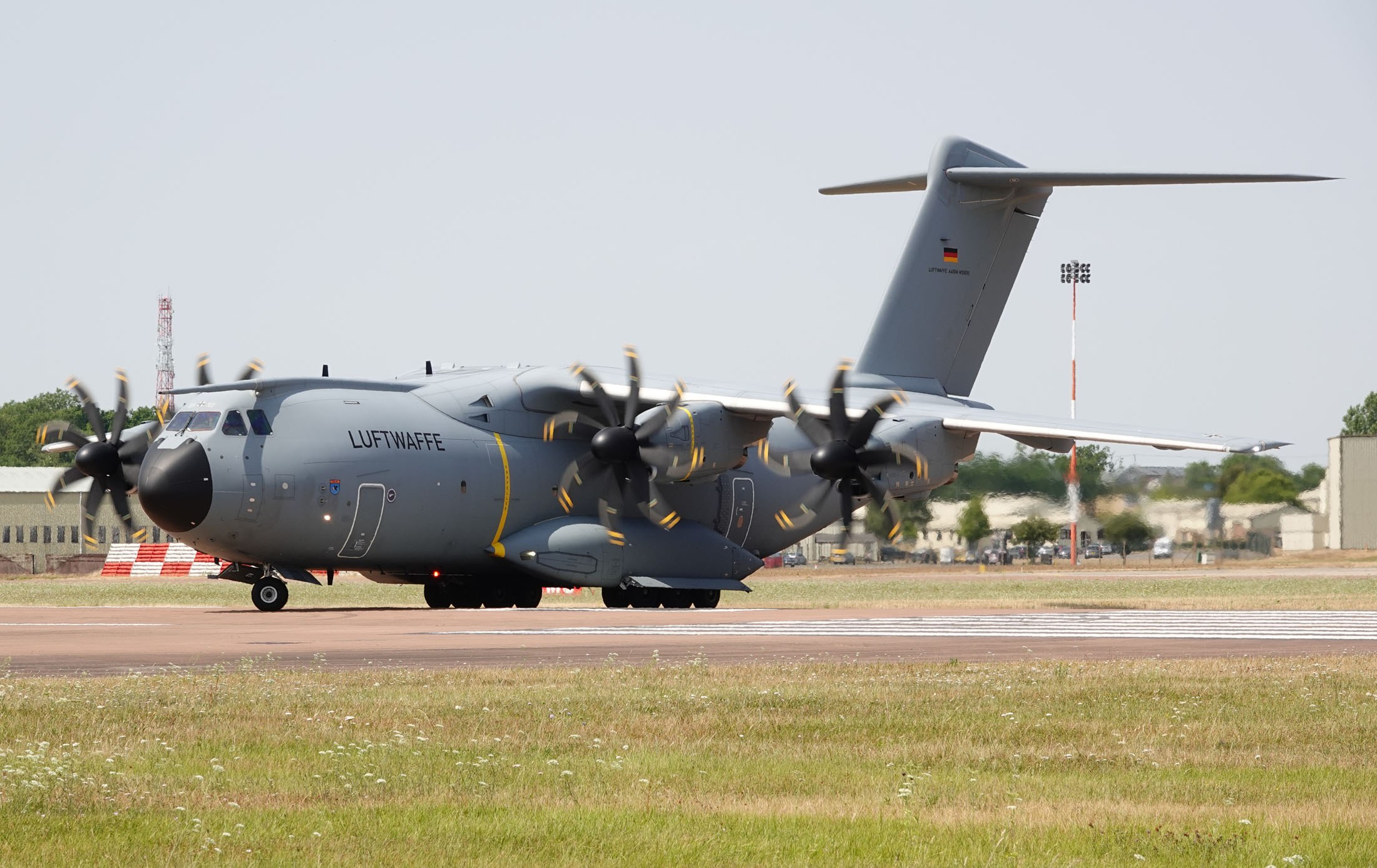 Luftwaffe Airbus A400M Atlas moving on a runway with propellers turning.