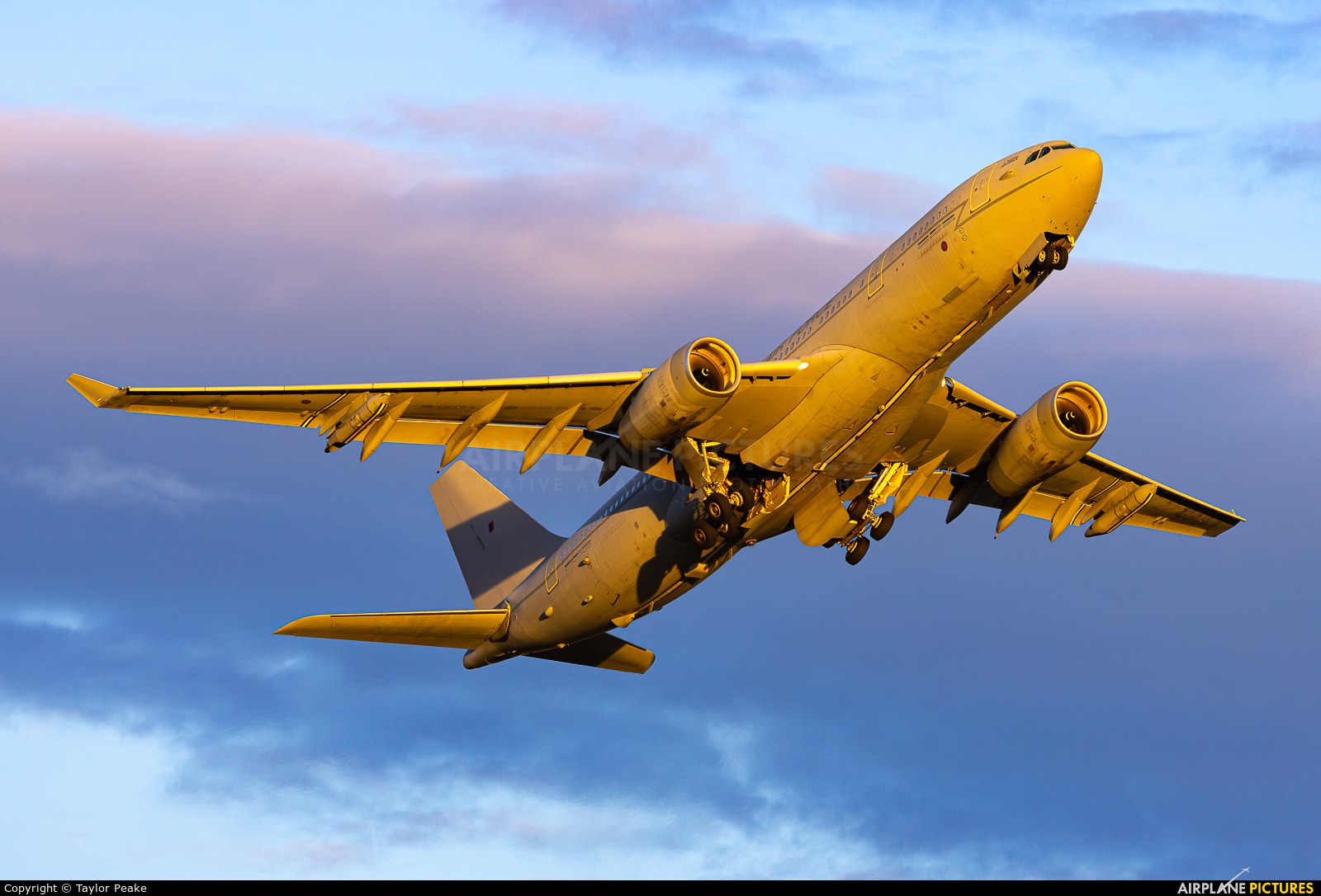 Royal Air Force Airbus Voyager climbing with landing gear extended in warm light.