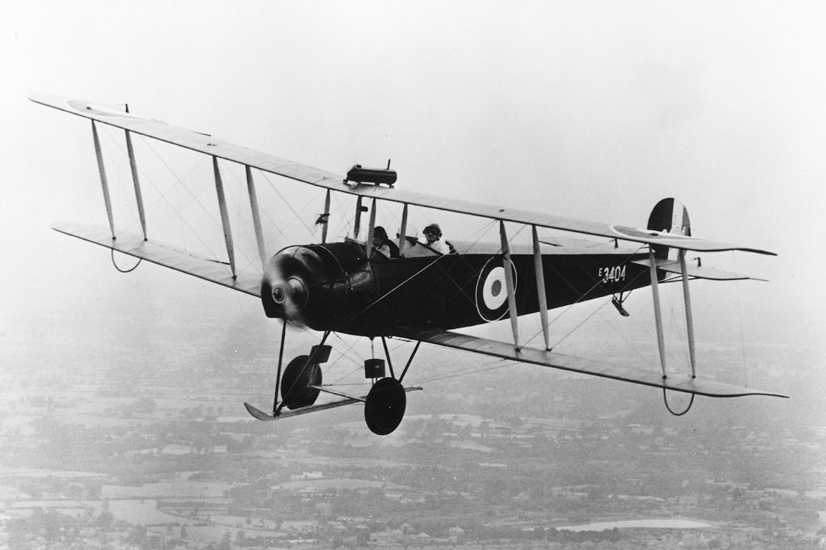 Black-and-white photograph of Avro 504 E3404 flying with two crew visible.