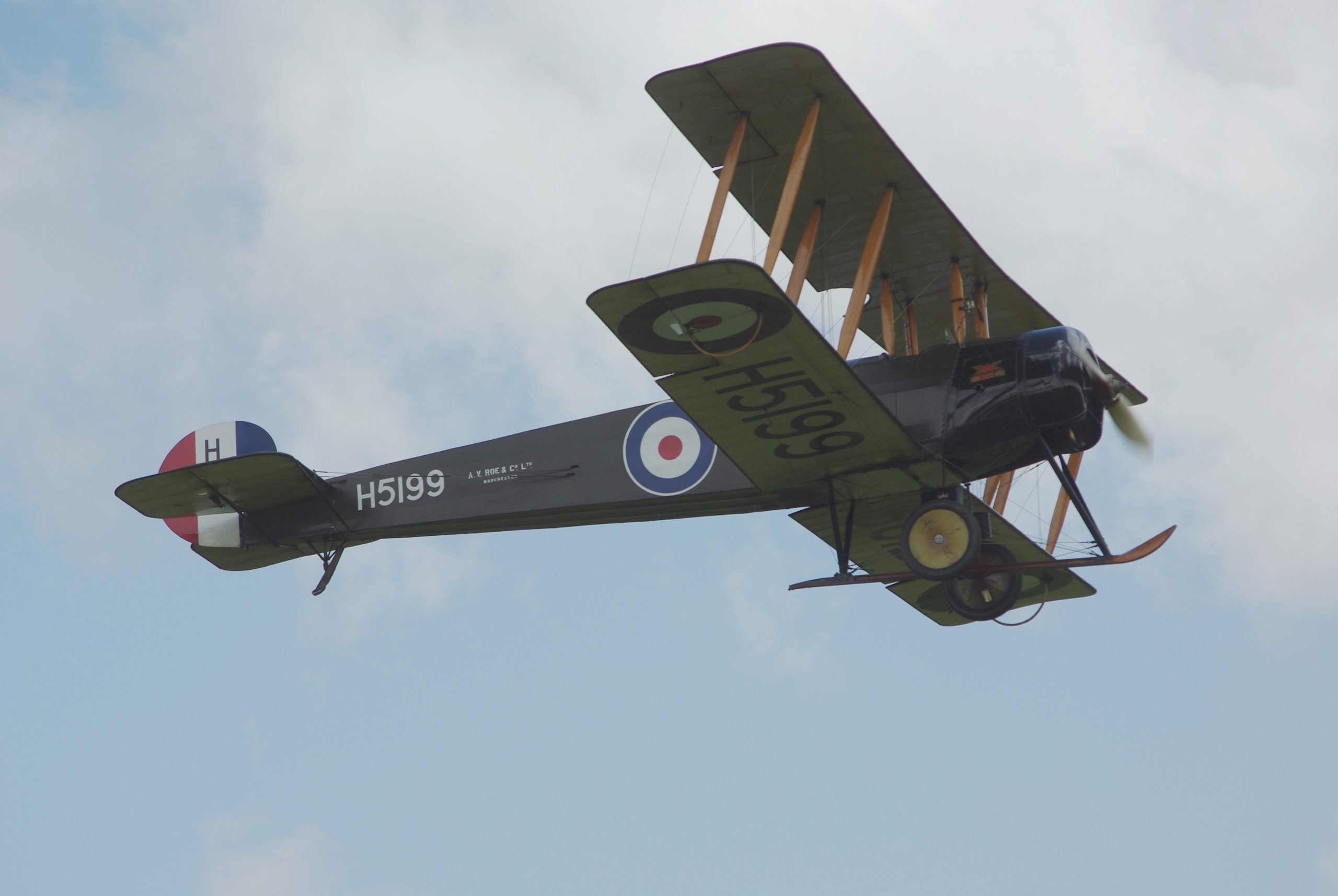 Close view of Avro 504 H5199 flying with RAF roundels and tail stripes.