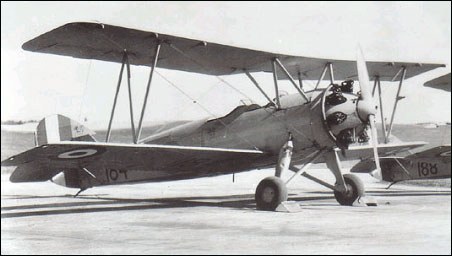 Black-and-white Avro biplane trainer 107 parked on an airfield.