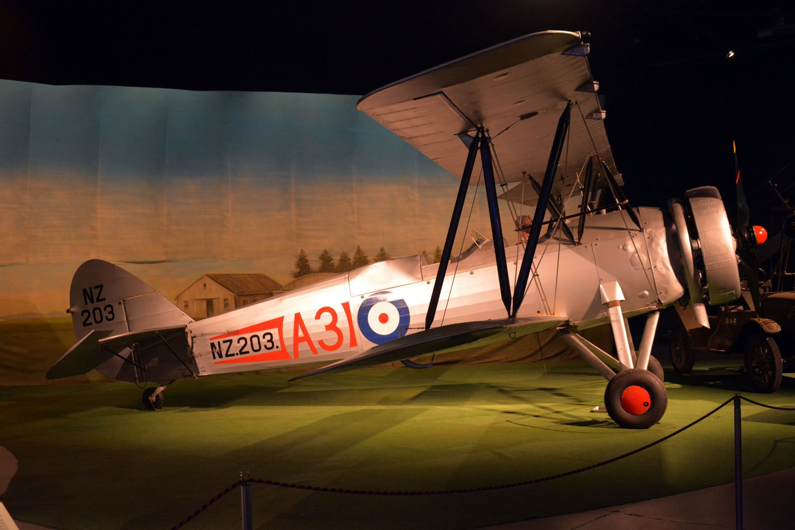 Avro 626 Prefect NZ203 lit warmly in a museum display.