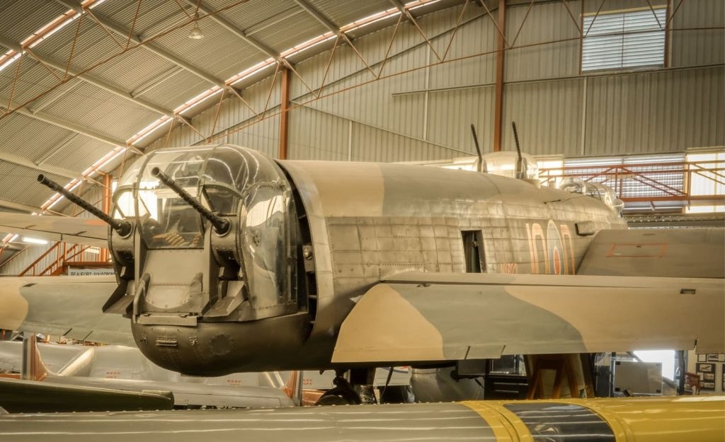 Preserved Avro Lancaster rear turret and fuselage inside a hangar.