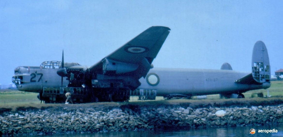 Avro Lincoln marked 27 parked near a shoreline with wing raised.