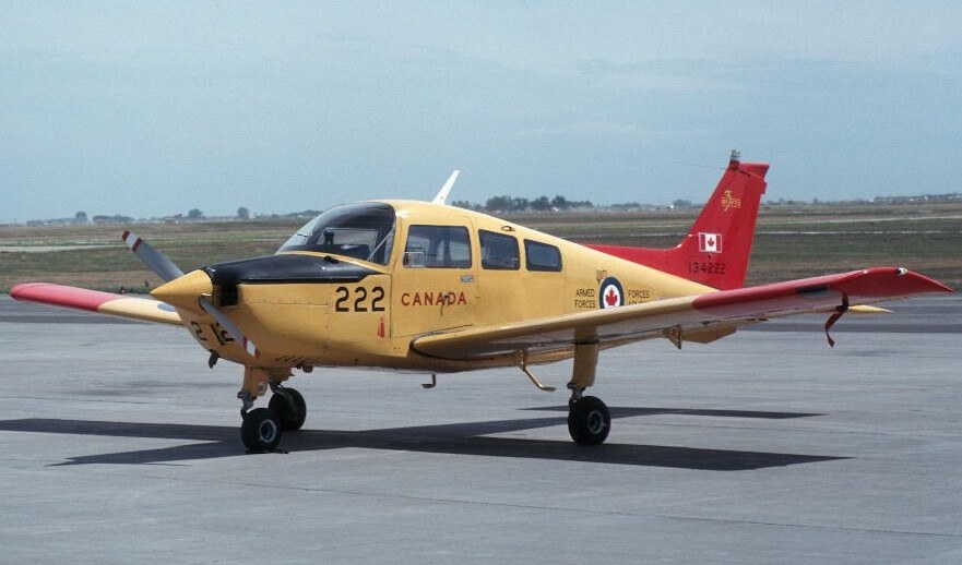 Beechcraft CT-134 Musketeer 134222 parked on an apron with red wings and tail.