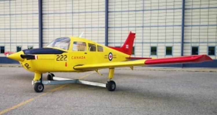 Beechcraft CT-134 Musketeer 222 parked in front of a hangar wall.