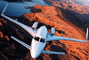 Beechcraft Starship in flight over desert terrain, showing the canard layout and pusher-propeller configuration of Beechcraft's composite business aircraft.