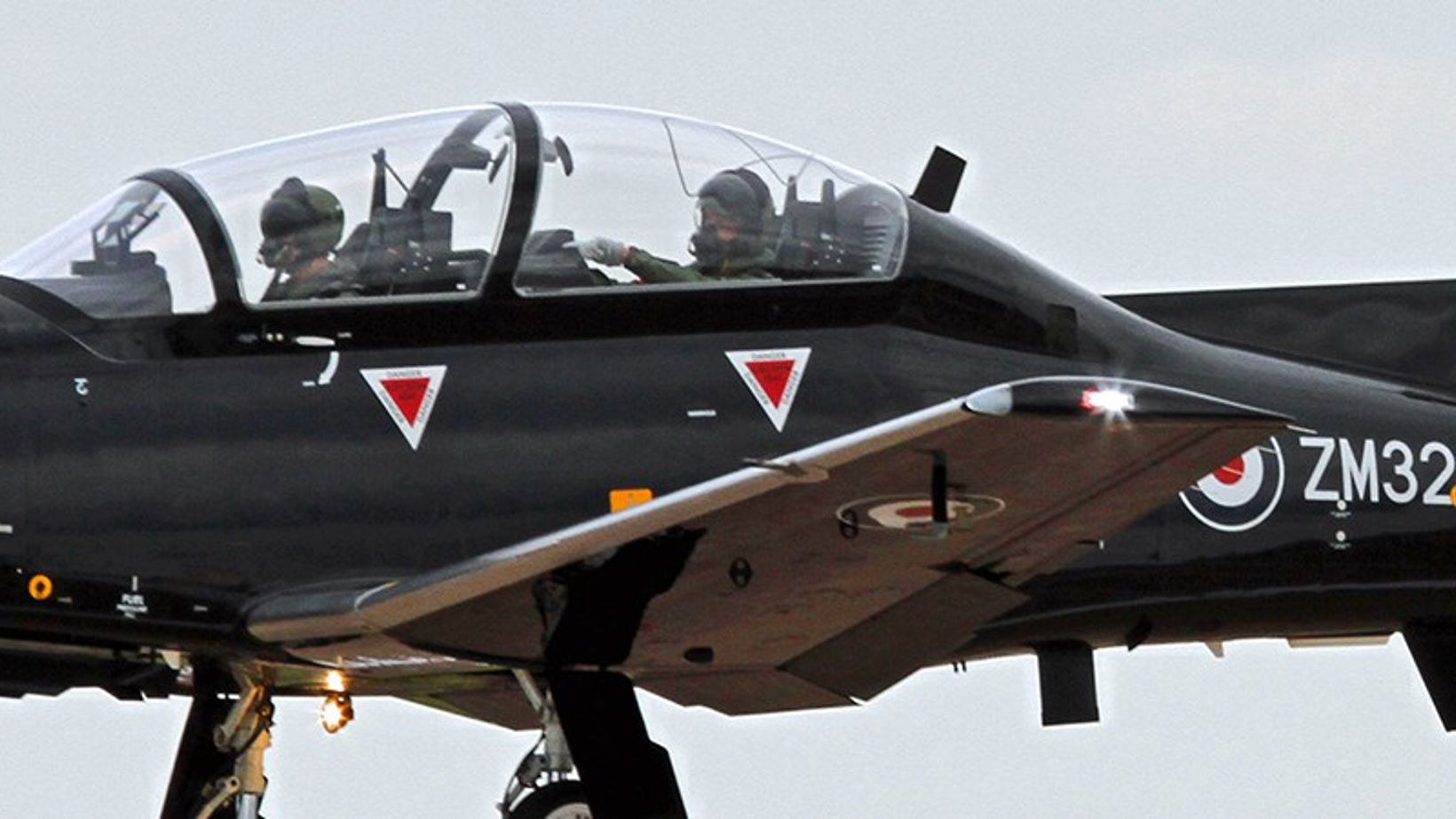 Close view of a black Beechcraft Texan T1 cockpit with two crew visible.