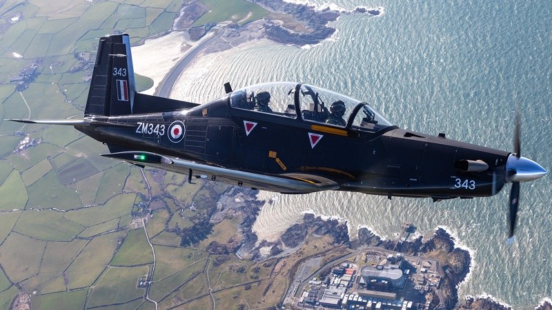 Black Beechcraft Texan T1 ZM343 flying over coastline and fields.