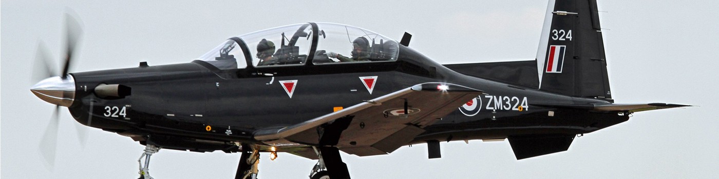 Black Beechcraft Texan T1 ZM324 flying with landing gear extended.
