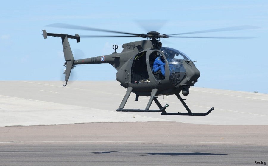AH-6 Little Bird numbered 230 hovering low above a runway with crew visible inside.