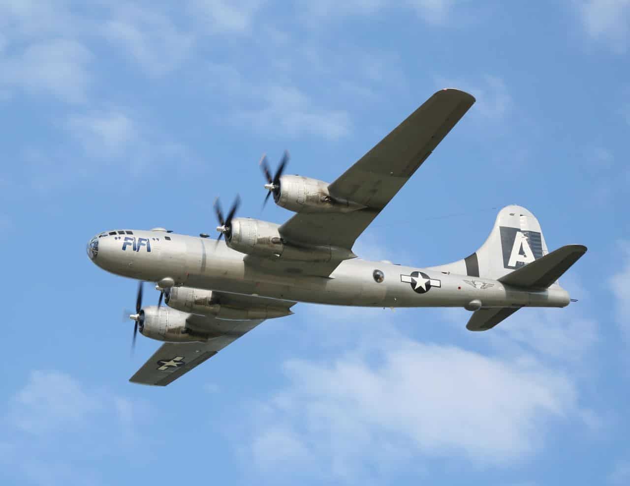 Silver Boeing B-29 FIFI flying with U.S. markings and all four propellers turning.