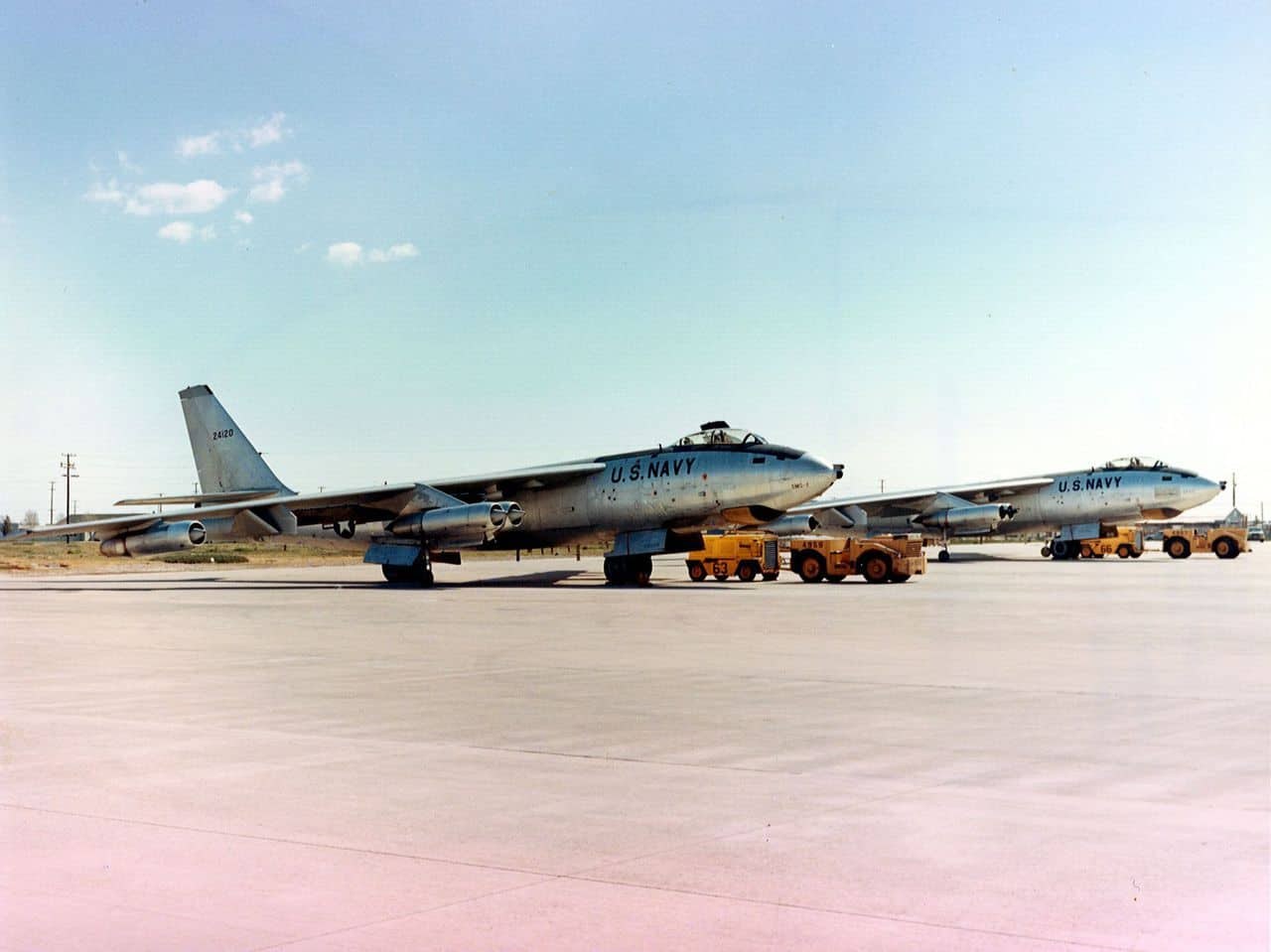 Two U.S. Navy Boeing B-47 aircraft parked on a concrete apron with tow tractors.