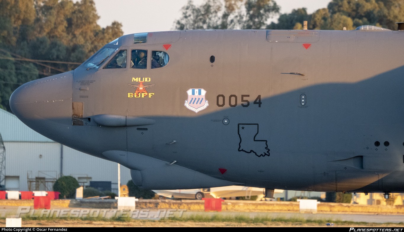 Close view of a gray Boeing B-52 nose with Mud Buff marking and number 0054.