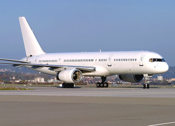 Plain white Boeing 757-type twinjet taxiing on a runway.