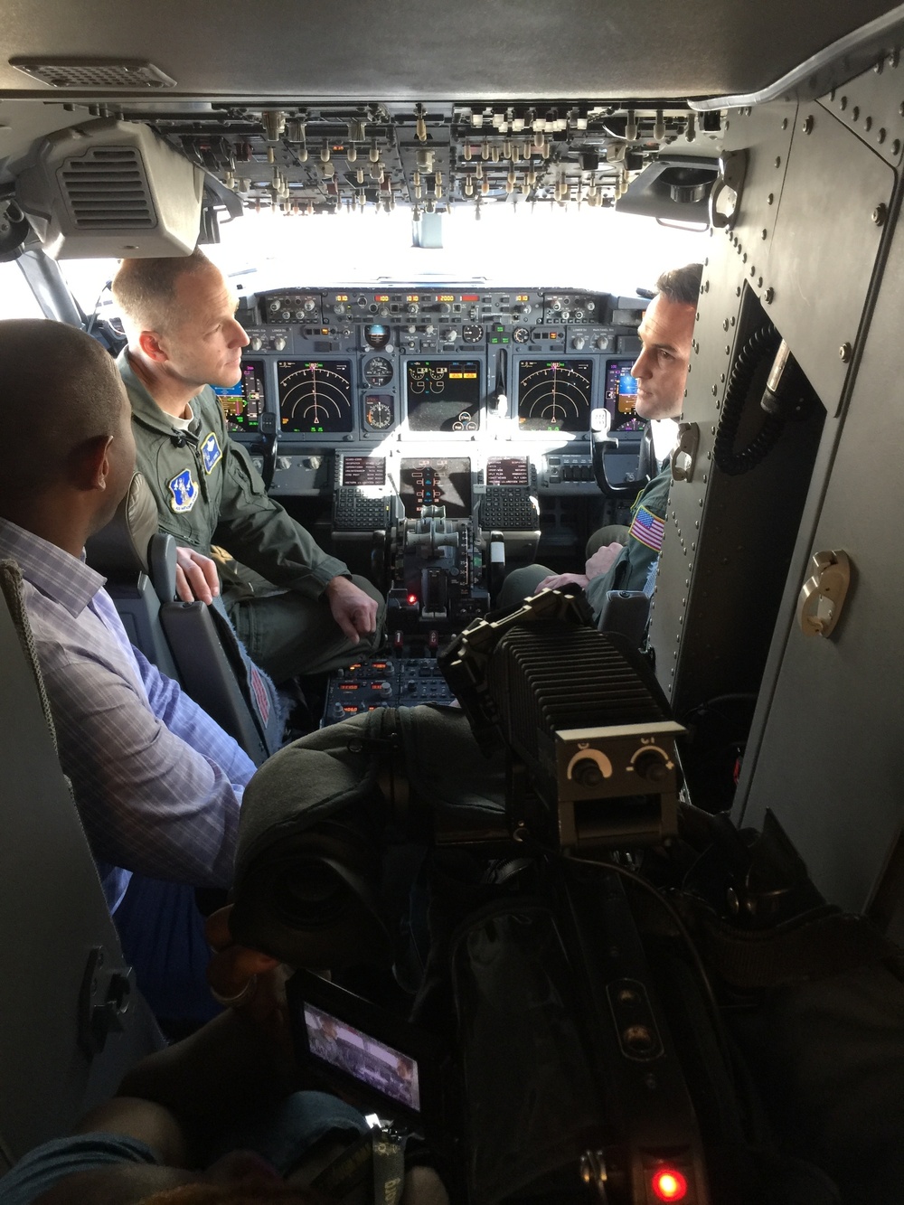 Boeing C-40 cockpit view with pilots, instrument panels, and overhead switches.