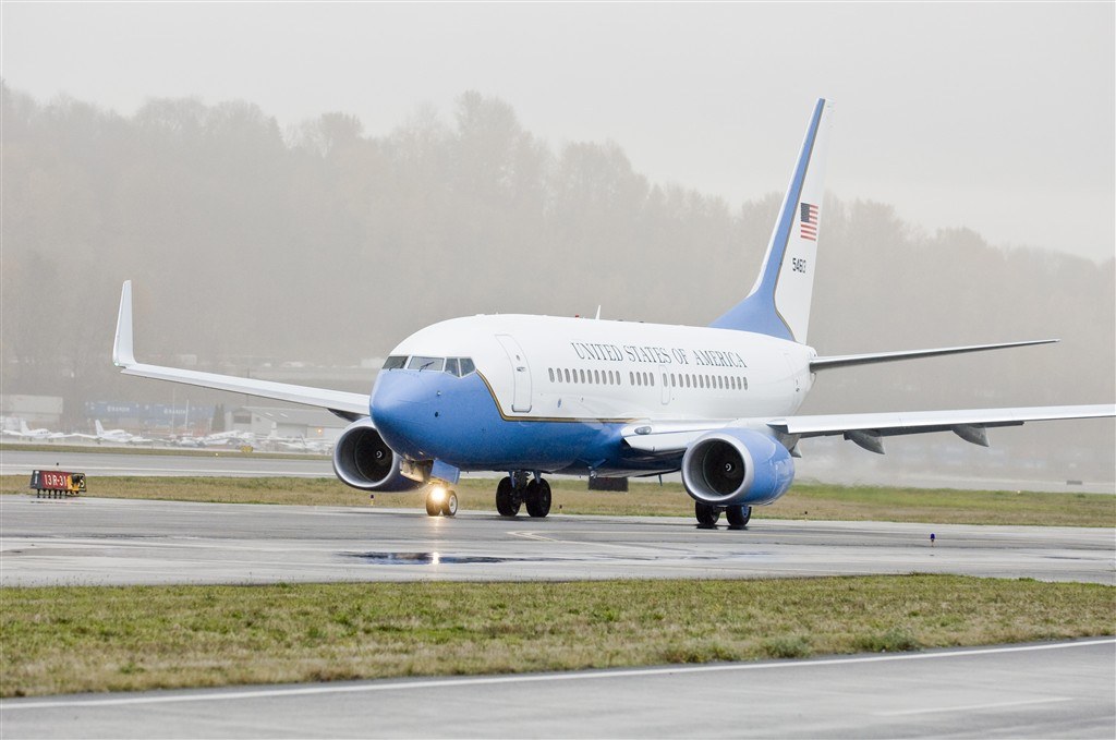 Blue-and-white Boeing C-40 5681 taxiing on a wet runway.
