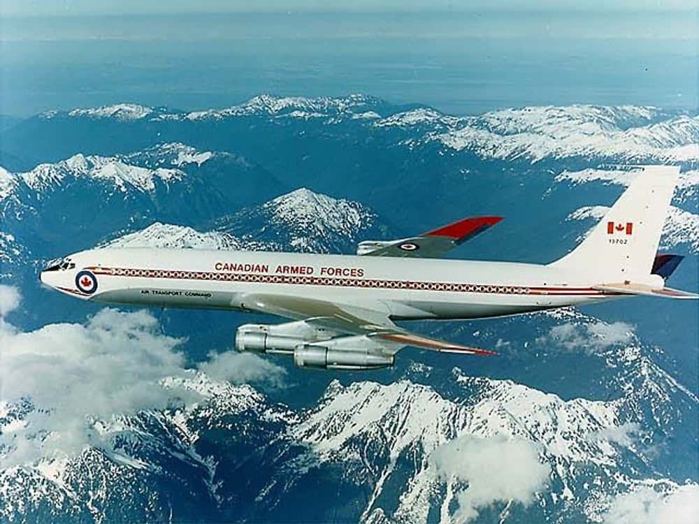 Canadian Armed Forces Boeing CC-137 13702 flying over snowy mountains.