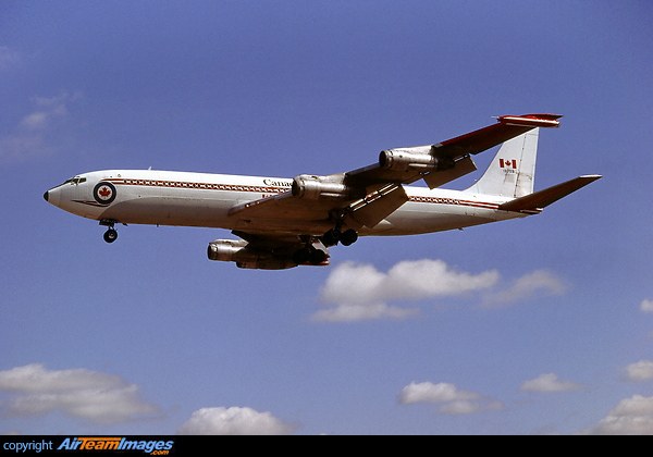 Canada Boeing CC-137 flying with landing gear extended against a blue sky.
