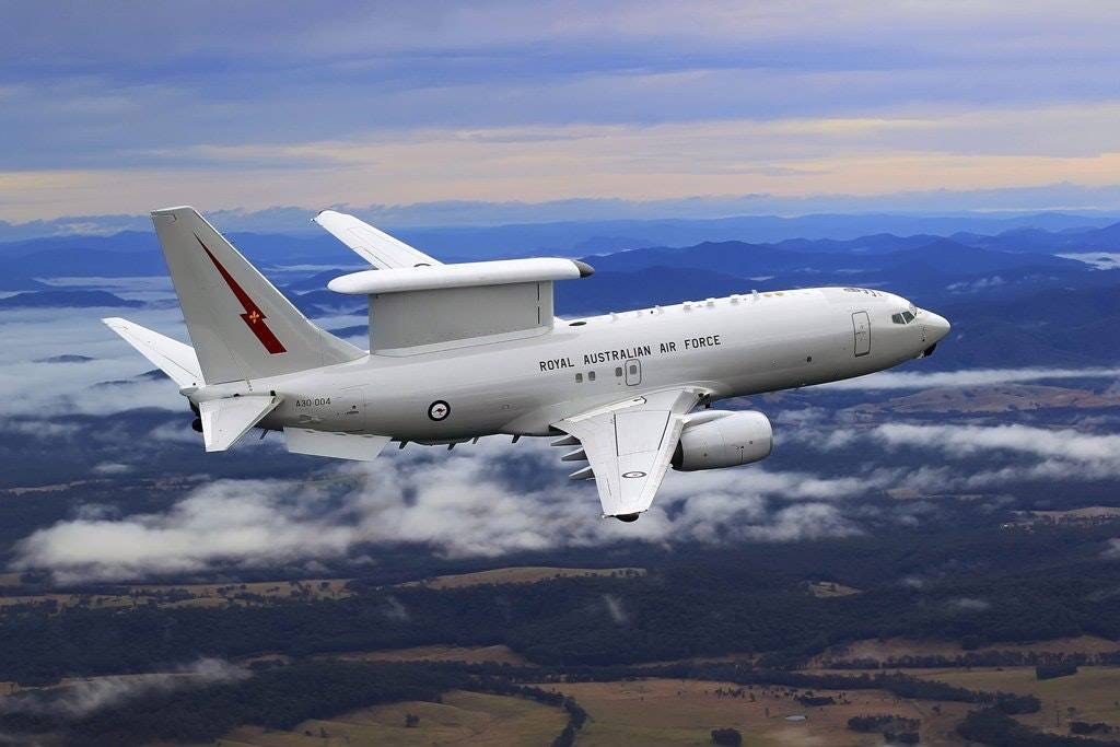 Royal Australian Air Force Boeing E-7 Wedgetail A30-004 flying over hills and clouds.