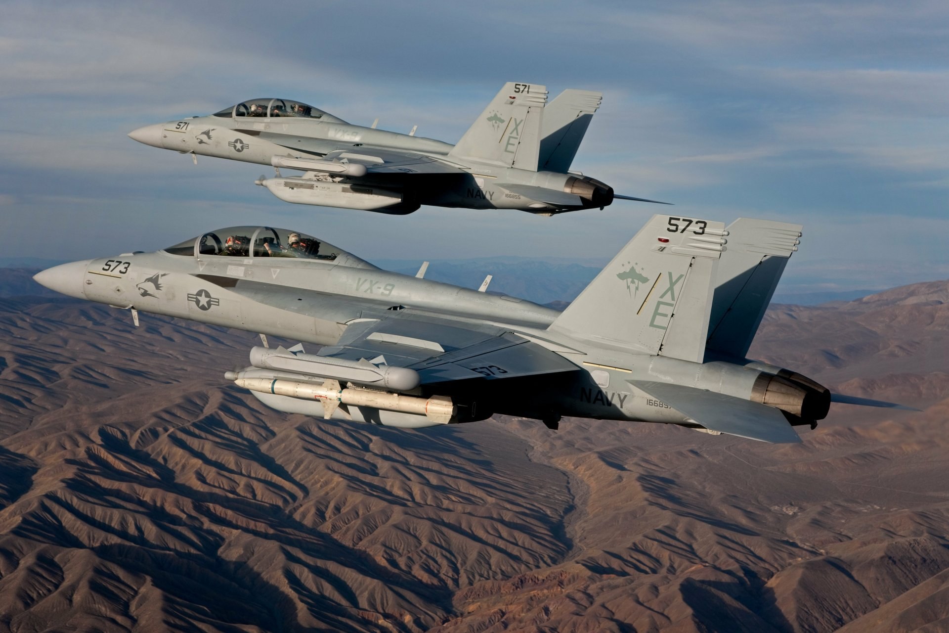 Two U.S. Navy Boeing EA-18G Growlers numbered 571 and 573 flying in formation.