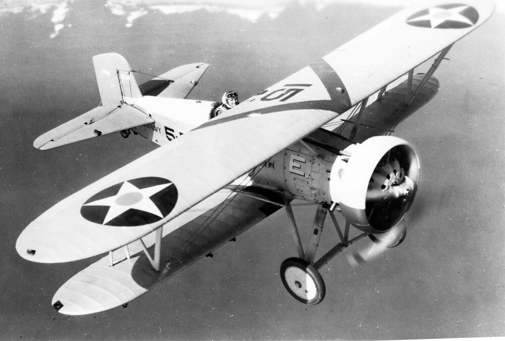 Boeing F4B biplane flying with U.S. star roundels visible on the wings.