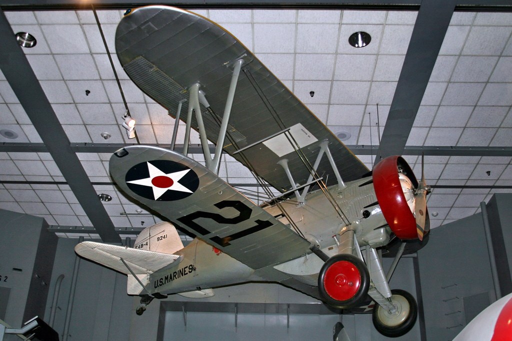 U.S. Marine Corps Boeing F4B-4 suspended indoors with red wheels and cowling.