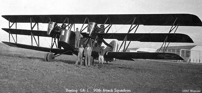 Boeing GA-1 triplane on grass with people standing near the nose.