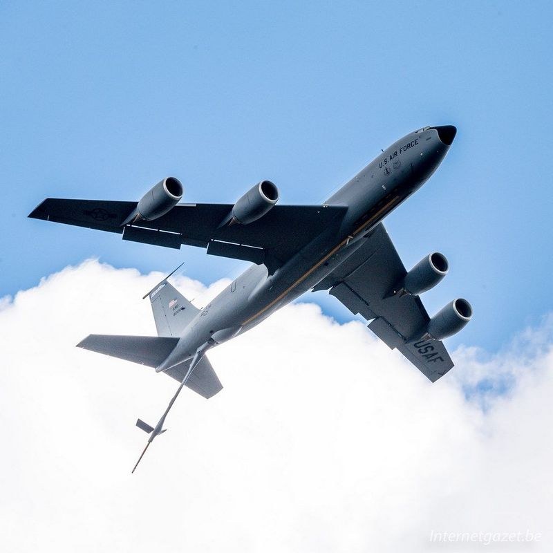 KC-46 Pegasus flying above clouds with its refueling boom extended.