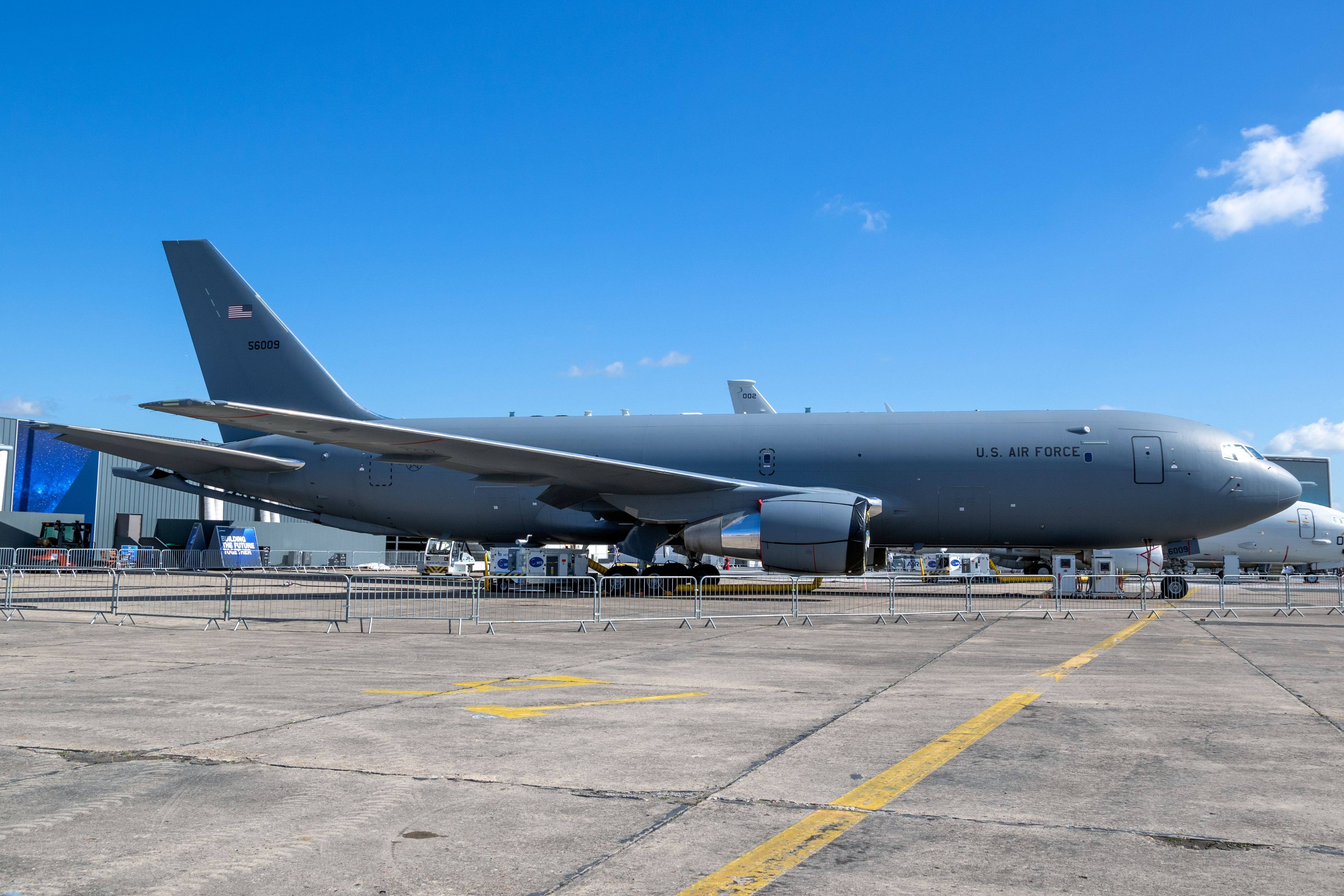 KC-46 Pegasus 56009 parked on a ramp behind crowd barriers.