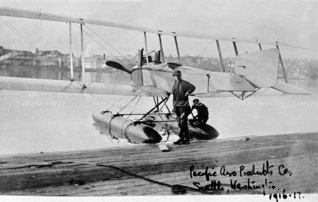 Boeing Model C floatplane at a Seattle dock with a person standing on the float.