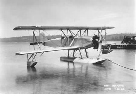 Boeing NB biplane on twin floats beside a dock.