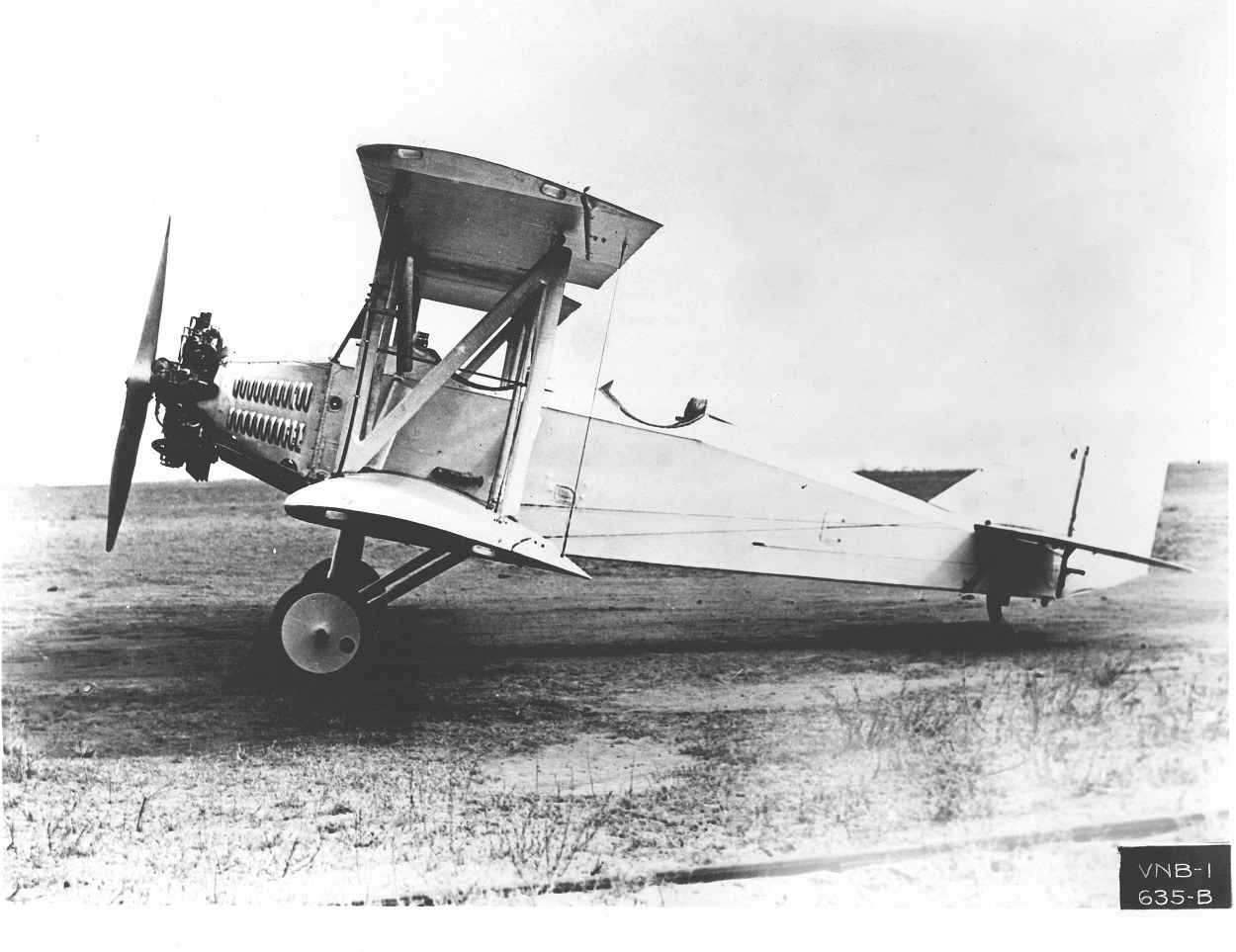 Boeing NB-1 biplane in a left side view on a field.