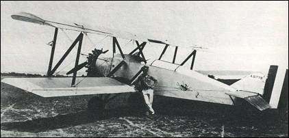 Boeing NB biplane A-6776 with a person standing beside the fuselage.