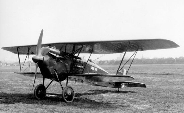 Black-and-white view of a Boeing PW-9 biplane parked on a grass field.