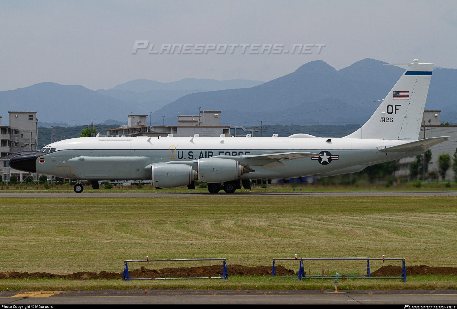U.S. Air Force RC-135 OF 62-4126 taxiing past mountains and buildings.