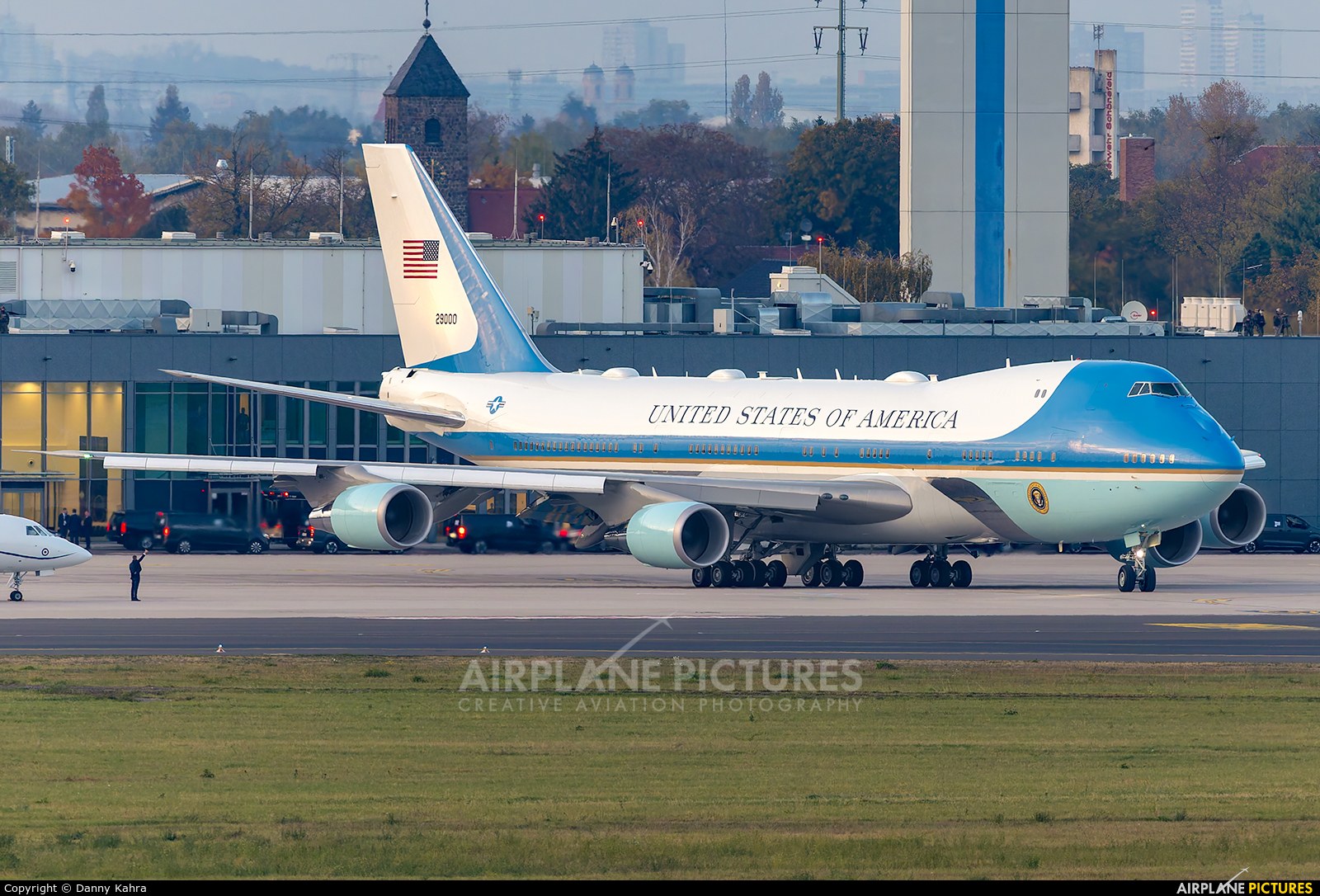 Boeing VC-25 29000 on an airport ramp beside terminal buildings.