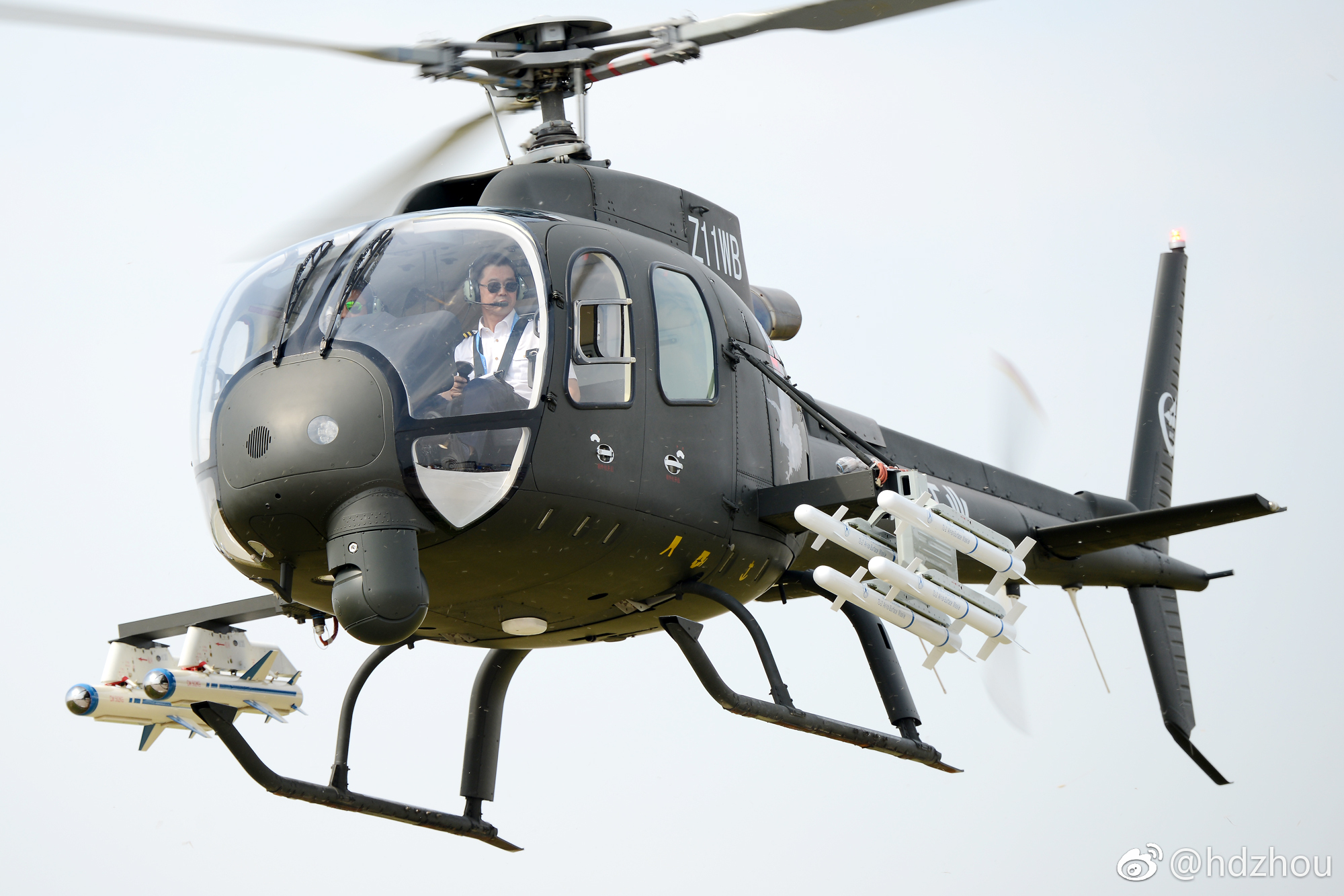 Changhe Z-11WB light attack helicopter flying with missile rails fitted.