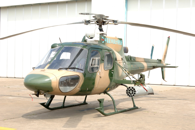 Changhe Z-11 army helicopter with camouflage paint and rocket pod.