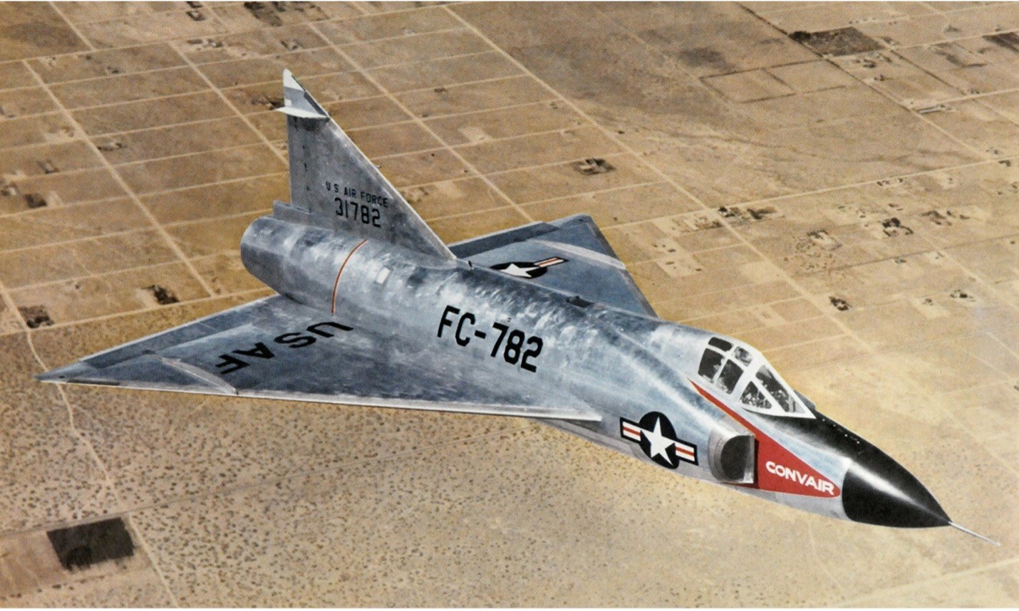 Color print of Convair F-102 Delta Dagger FC-782 above desert terrain.