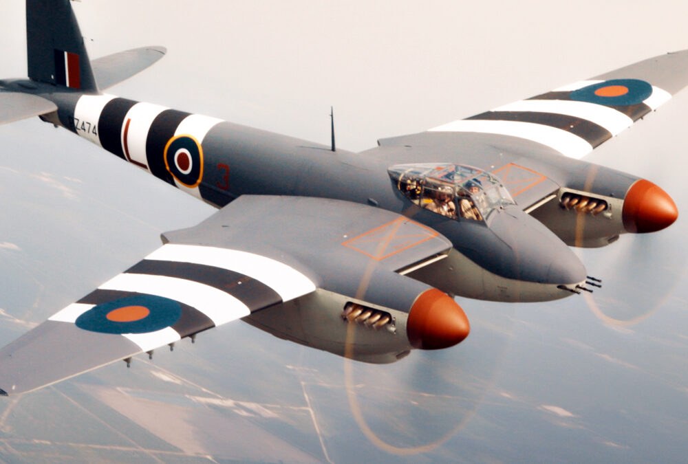 de Havilland Mosquito flying with invasion stripes and RAF roundels.