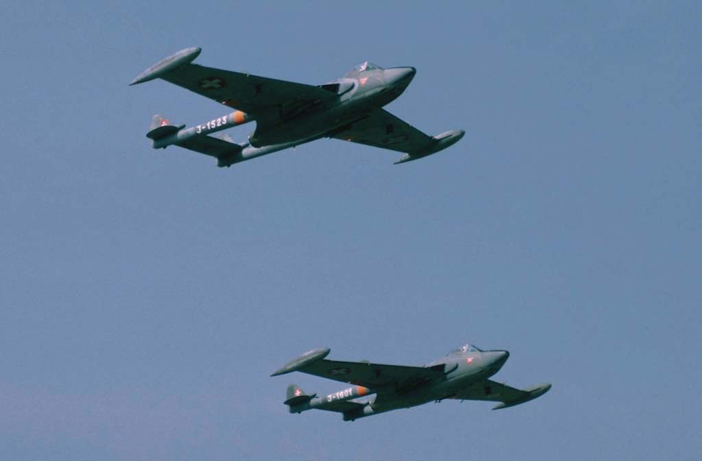 Two Swiss-marked de Havilland Sea Venom aircraft flying in formation.
