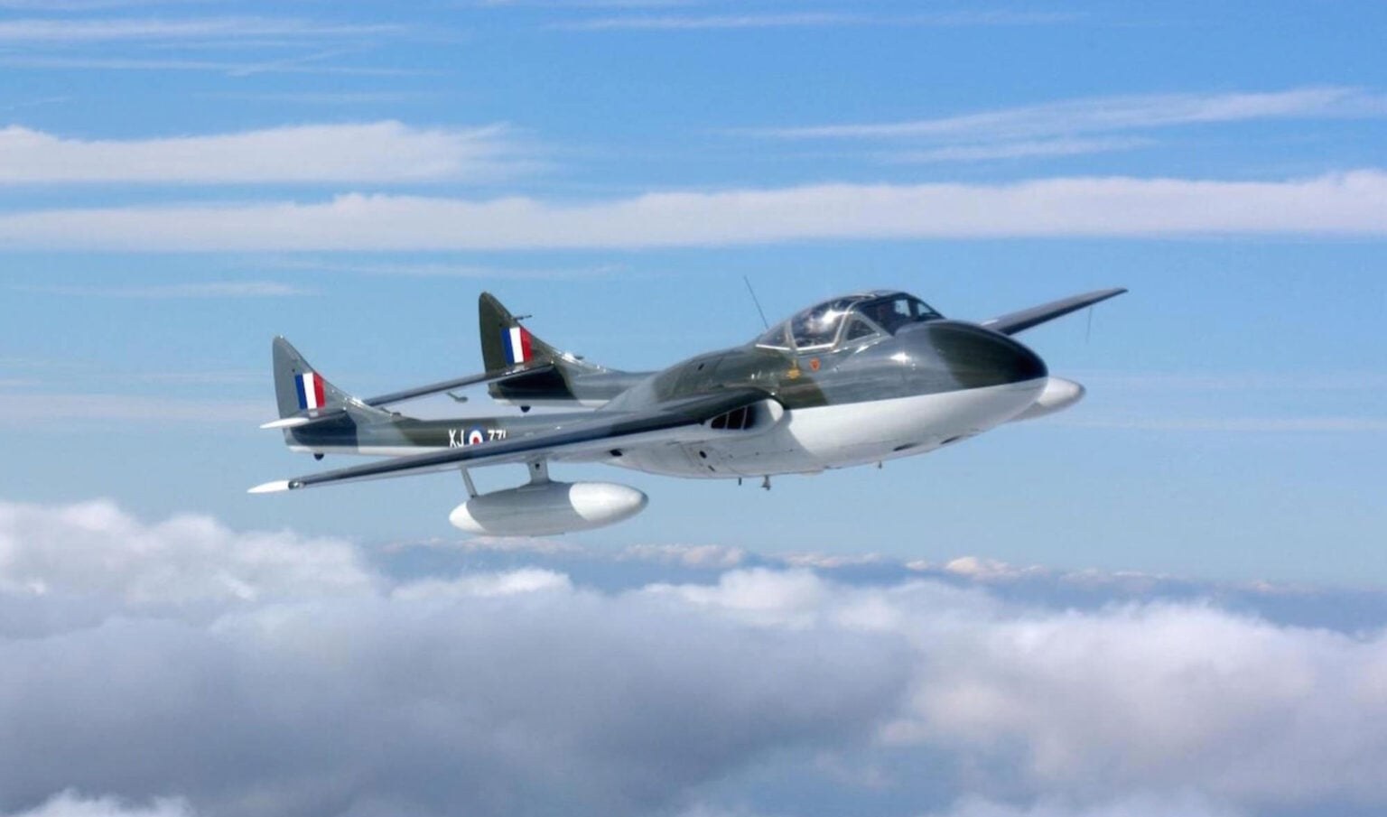 de Havilland Vampire XJ771 flying above clouds in front-left view.