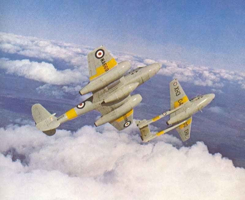 Two de Havilland Vampire aircraft flying above clouds with yellow band markings.