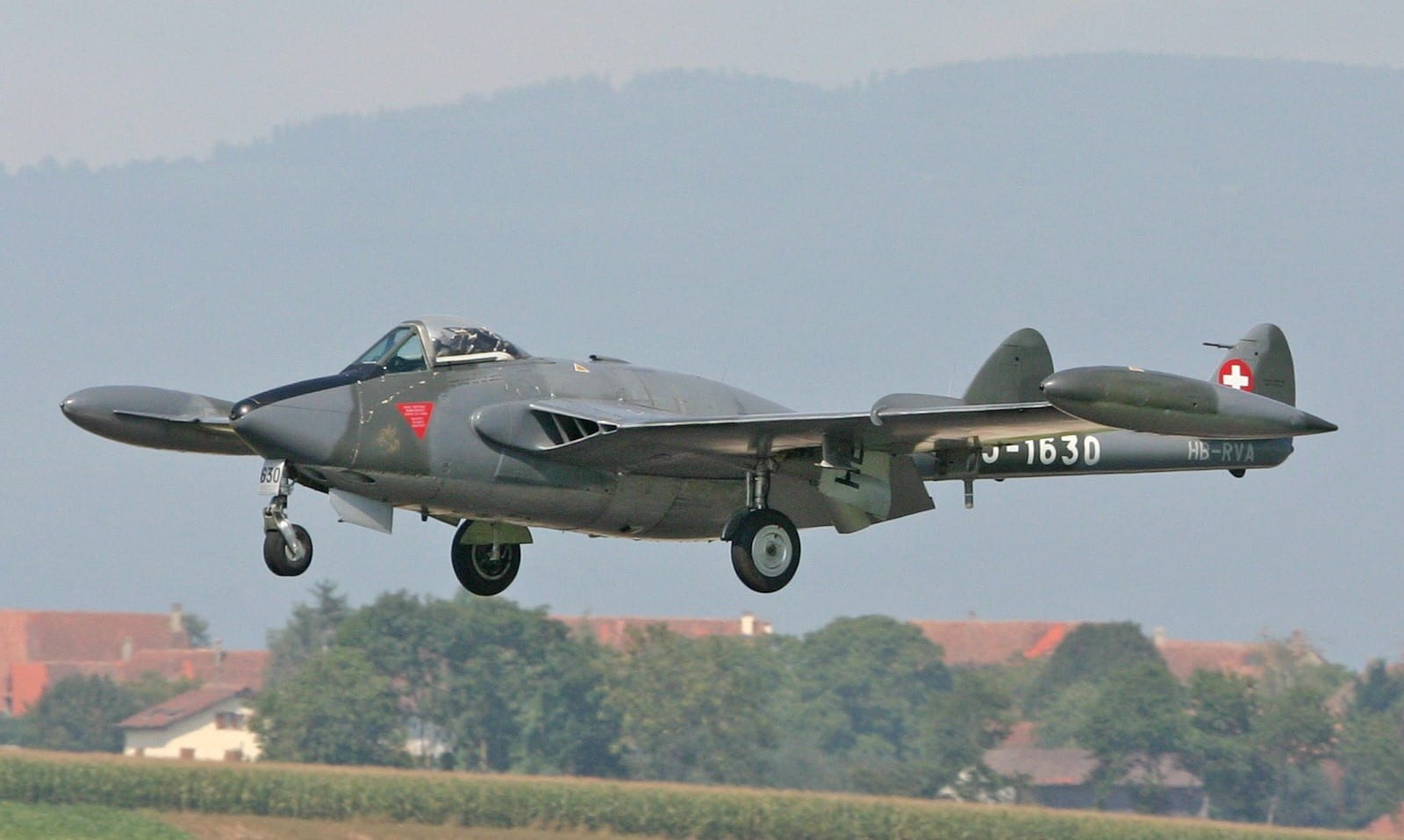 Swiss-marked de Havilland Venom J-1630 flying low with landing gear extended.