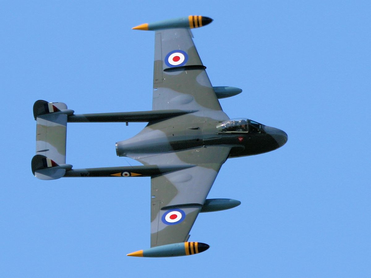 Camouflaged de Havilland Venom photographed from below with RAF roundels visible.