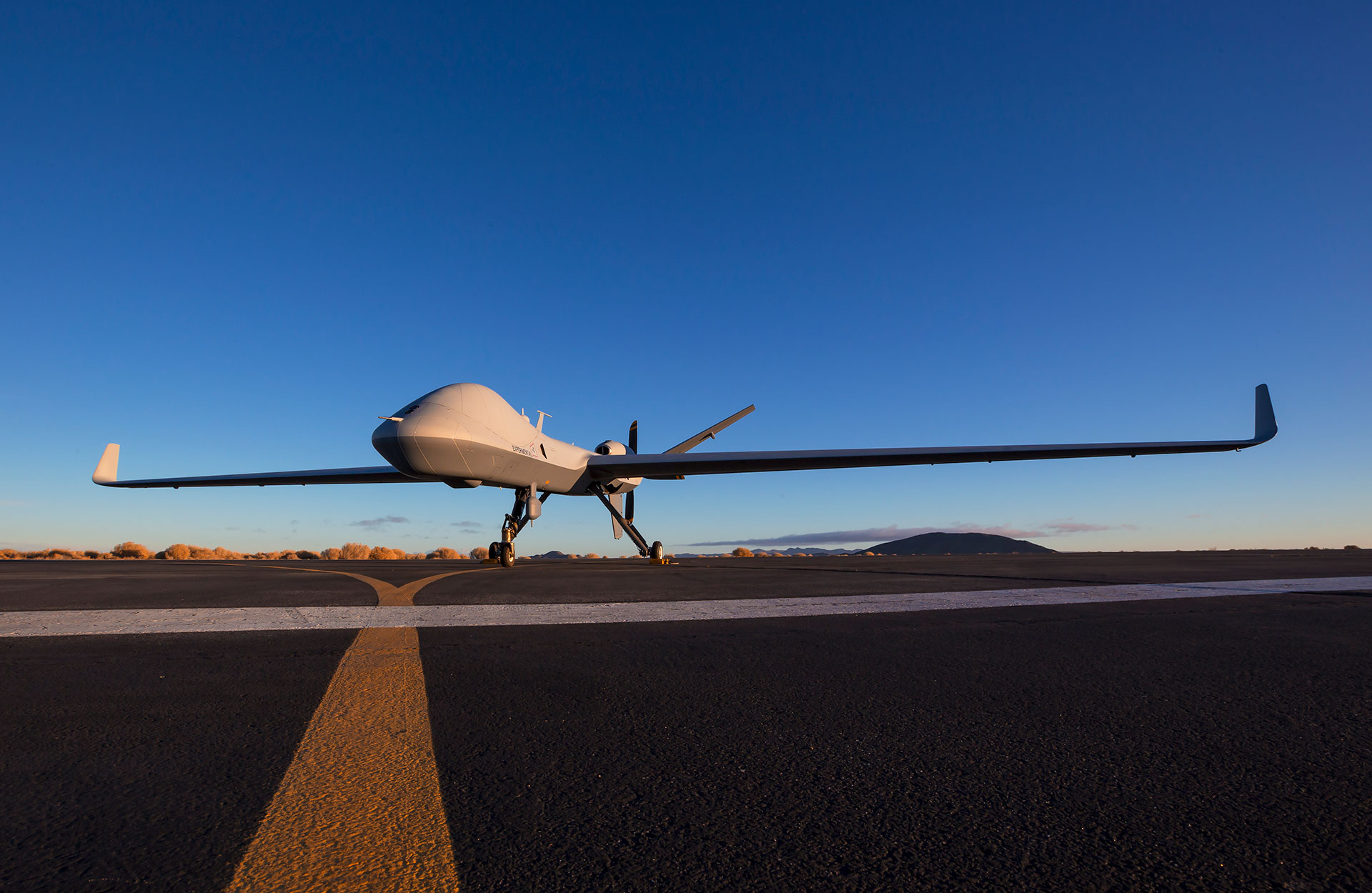GA-ASI SkyGuardian unmanned aircraft on a runway at dusk